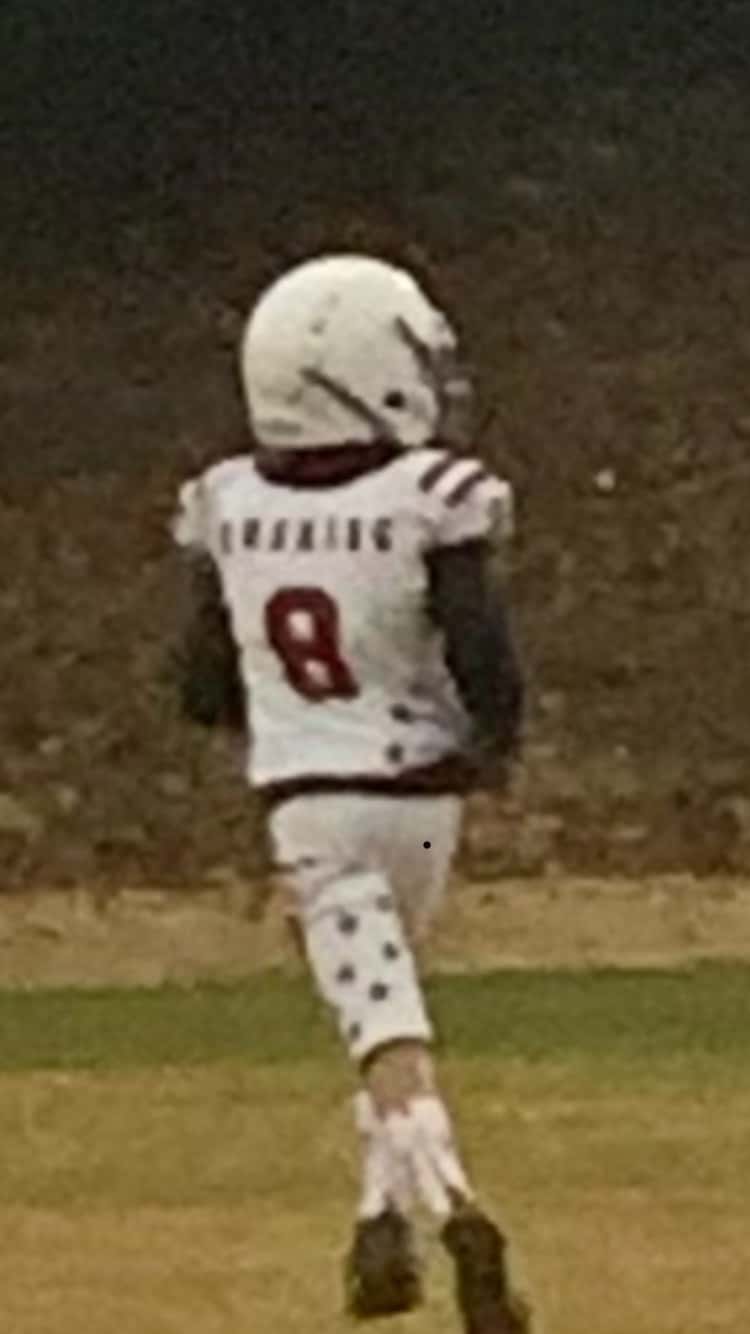 boy in football uniform running