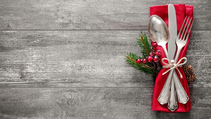 Christmas table place setting on grey wood background