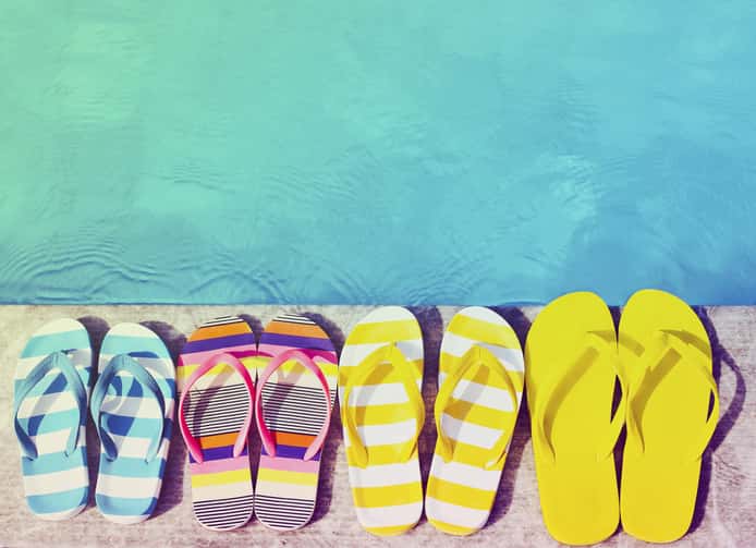 Flip flops on stone background on poolside.