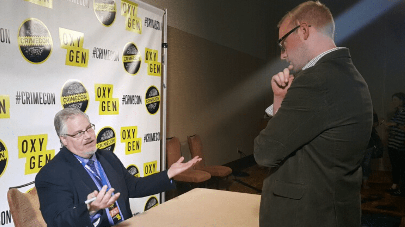 Sean Copeland standing and interviewing Ken Kratz