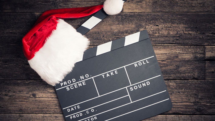 Santa hat on a clapperboard on a wood background