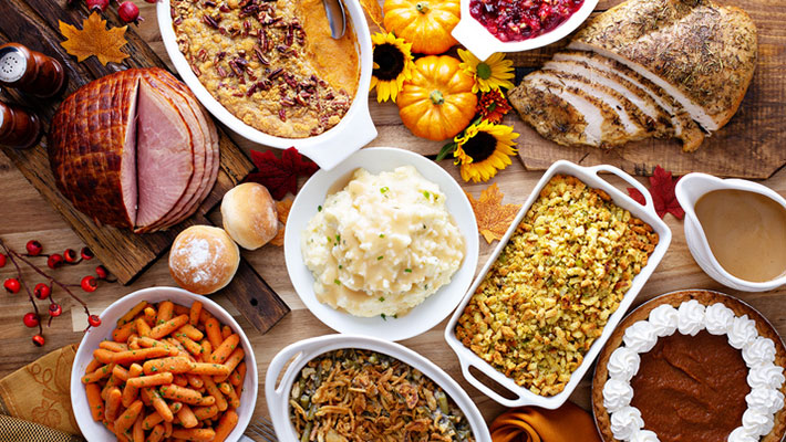 Thanksgiving turkey and ham on a table with side dishes