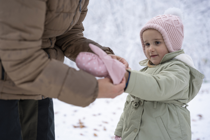 Winter Family Fun in Snow Forest. Mom & Child Prepare for a Hike