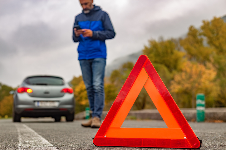 Car breakdown on a rural road in autumn with adverse weather conditions.