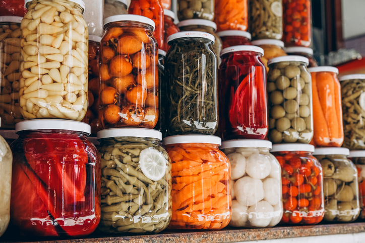 Closeup of canned vegetables in glass jars on the table in the market. Homemade vegetables preserves.